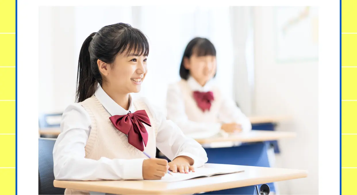 教室で笑顔でノートに向かう女子中学生